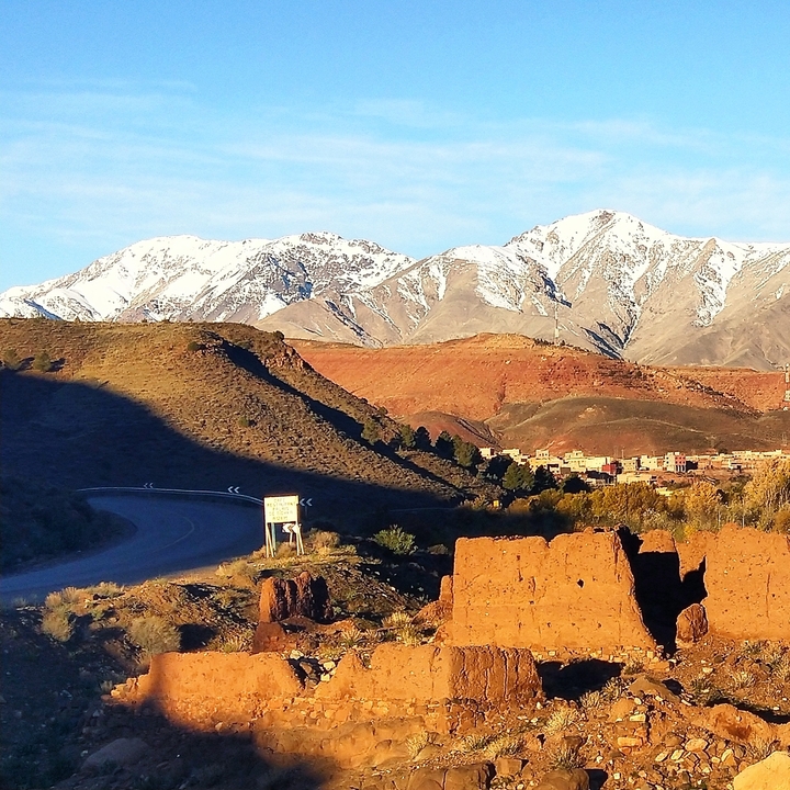 Paysage désertique avec montagnes et village au loin.