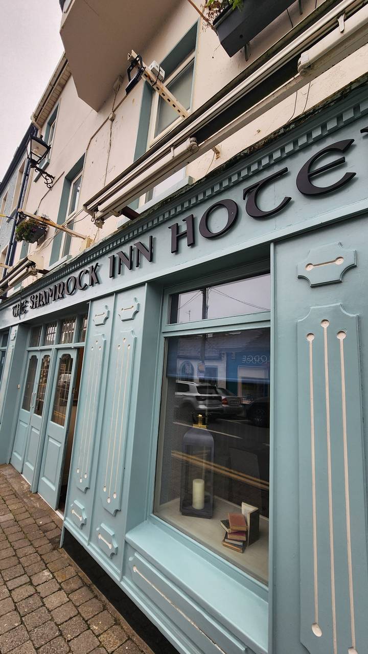 Vue latérale d'une auberge traditionnelle avec enseigne.