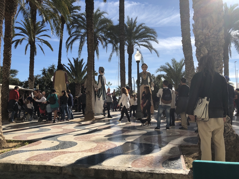 Festival en plein air avec de grandes figures et des spectateurs.