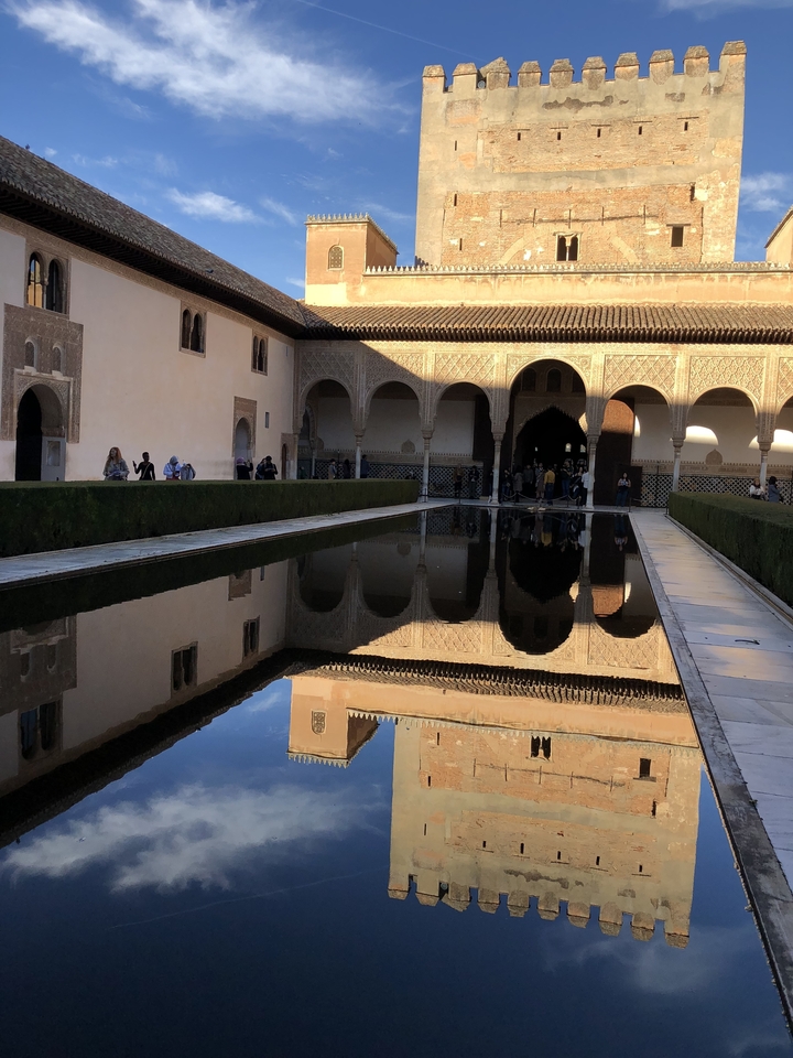 Reflective pool in an ornate architectural courtyard.