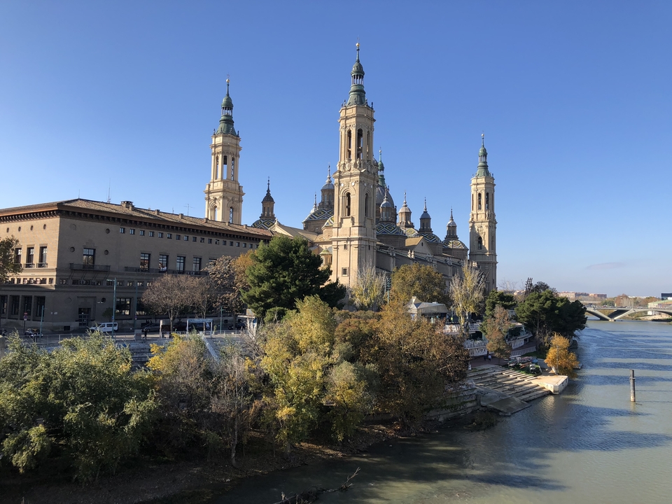 Basilica by the river with towers in the city.