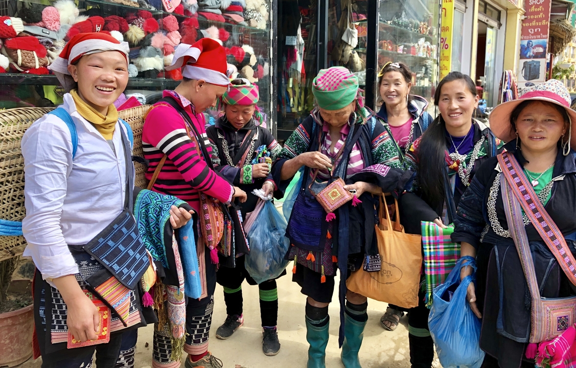 Groupe de femmes en tenue traditionnelle sur un marché local.
