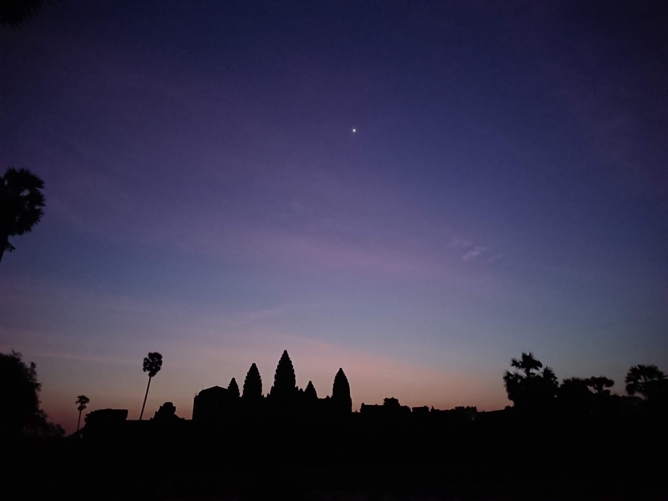 Une silhouette d'une structure de temple contre un ciel crépusculaire.