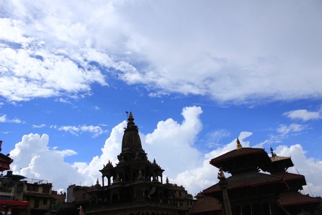 Une silhouette de temple sur un fond de ciel nuageux.