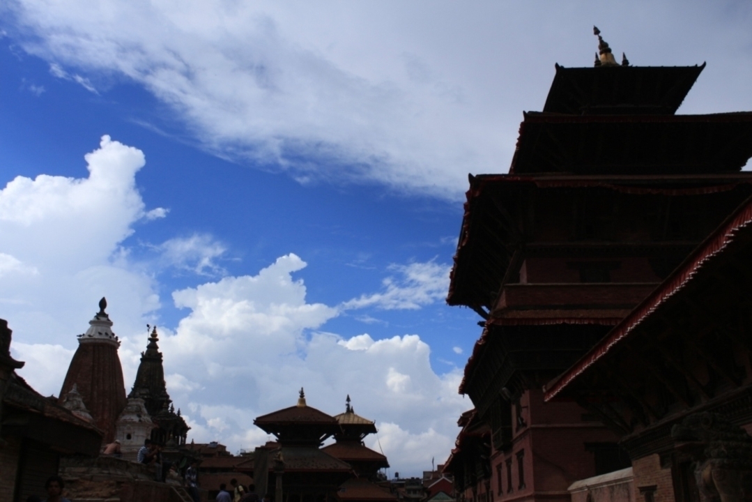 Des temples en silhouette contre un ciel lumineux avec des nuages.