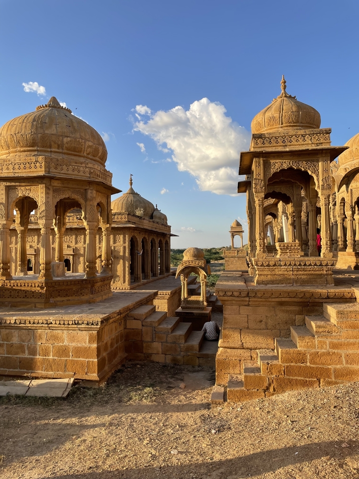 Chhatris ornés dans un site historique sous un ciel bleu.
