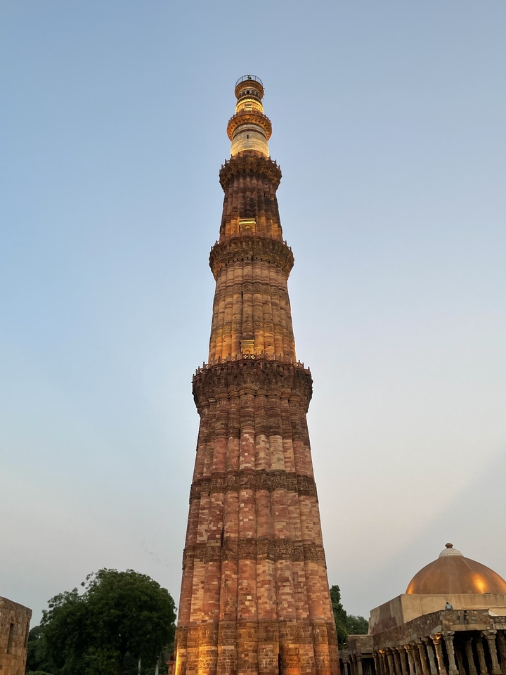 Une haute tour historique contre un ciel dégagé, Qutub Minar.