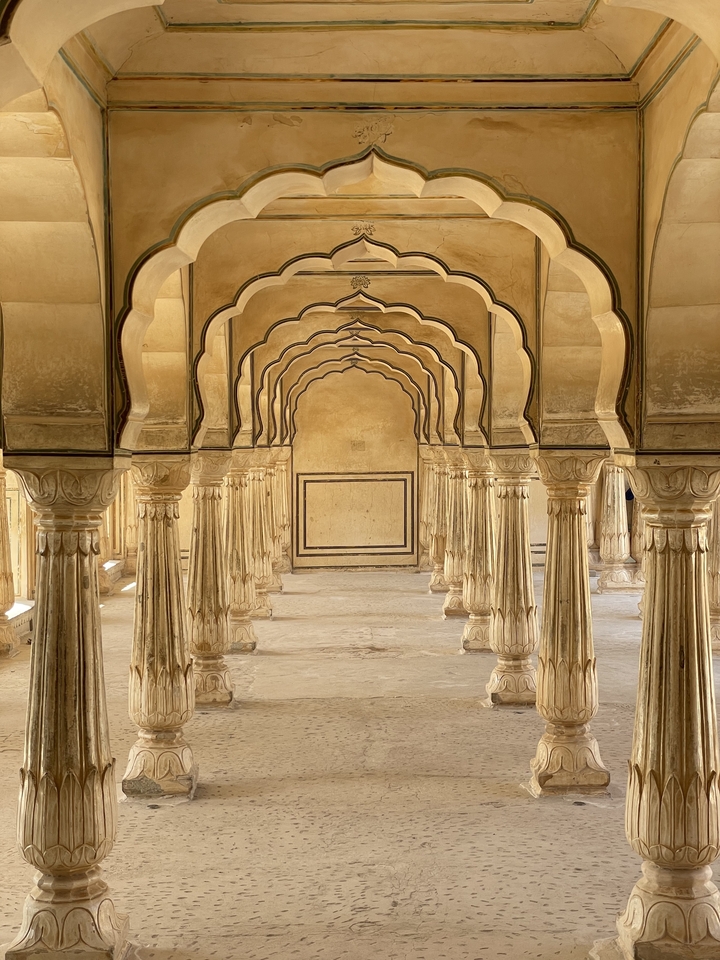 Série d'arches et de colonnes élégantes dans un bâtiment historique.