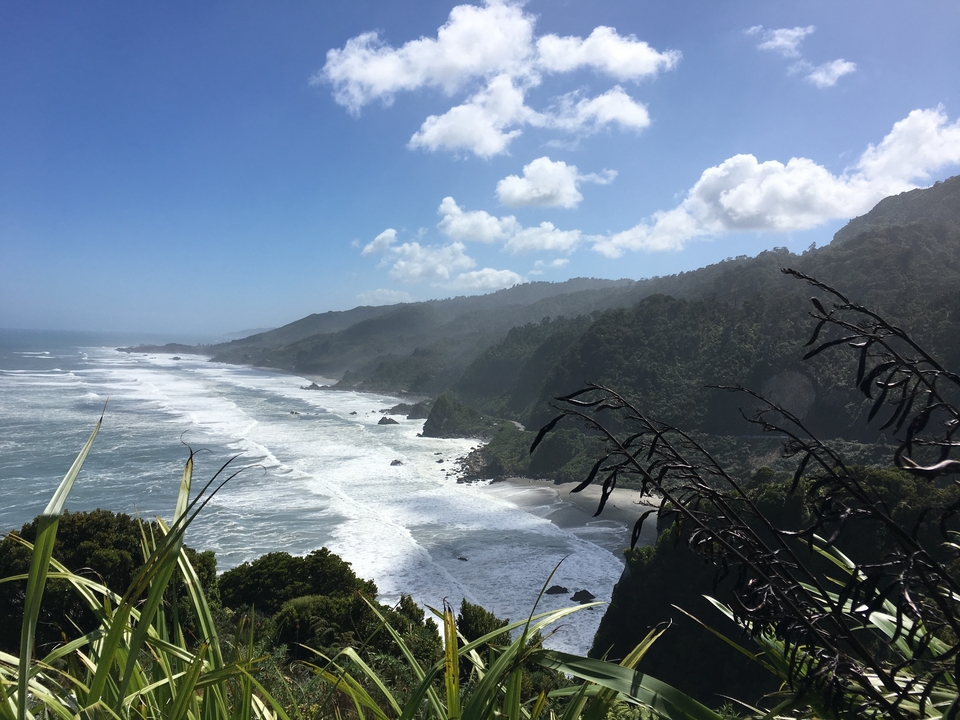 Paysage côtier avec des vagues qui se brisent contre des rivages rocheux.