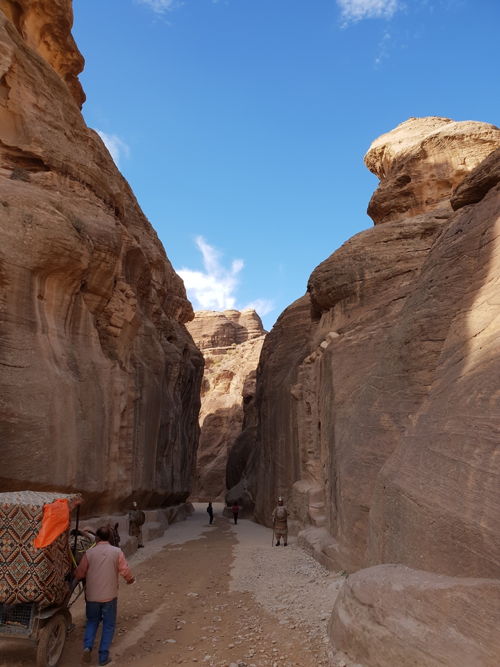 High rock walls under clear blue sky, forming a canyon.
