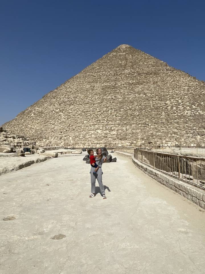 Dos personas posando frente a una pirámide.