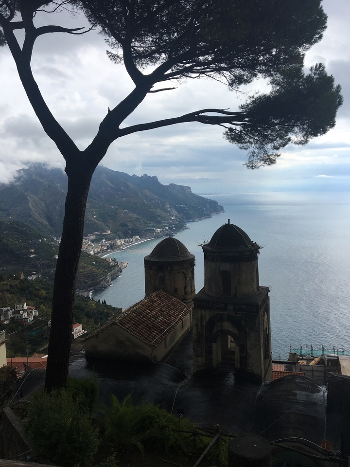 Vue côtière pittoresque avec des dômes d'église et une falaise en arrière-plan.