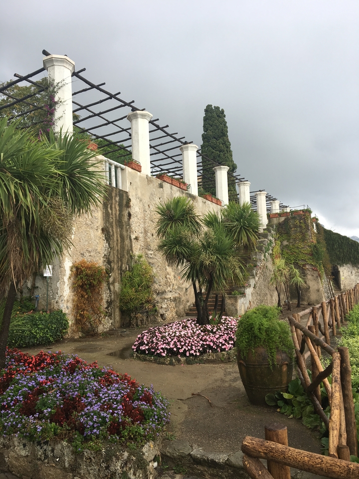 Vieux mur avec des plantes et un jardin au premier plan.