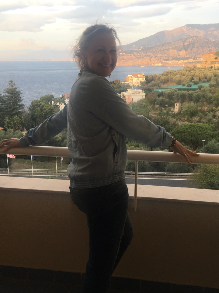 Personne debout sur un balcon avec vue sur le paysage.