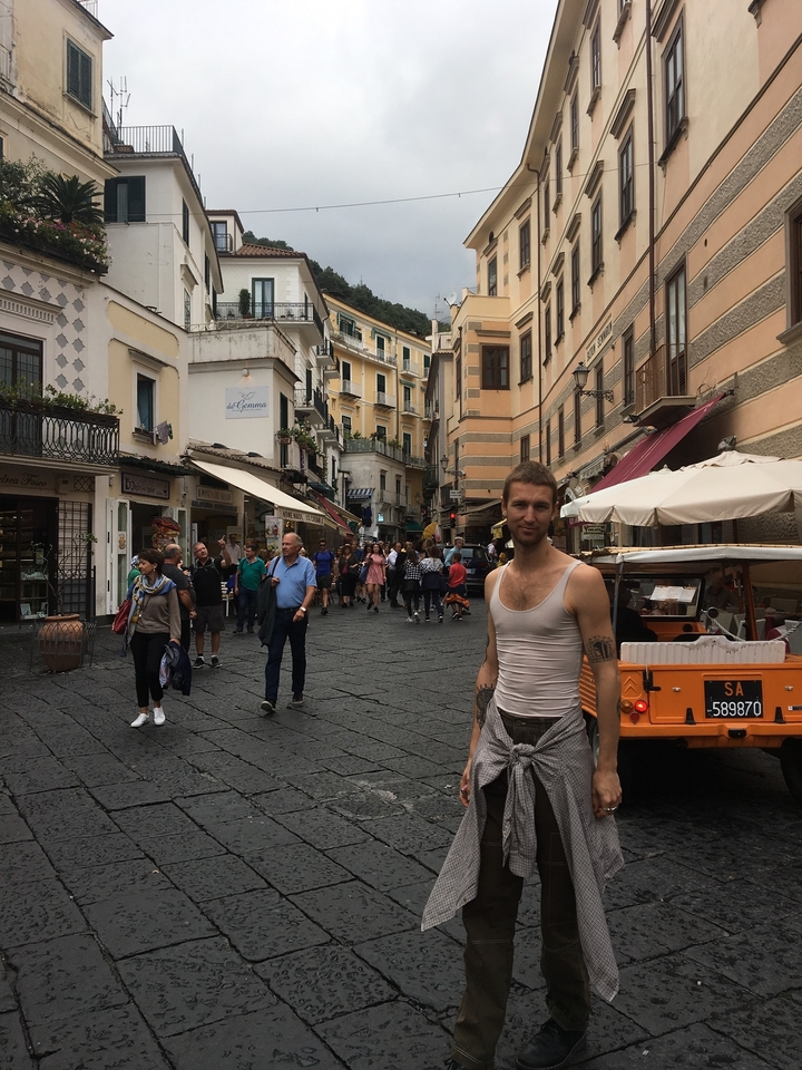 Rue animée dans une ville italienne avec des gens qui marchent.