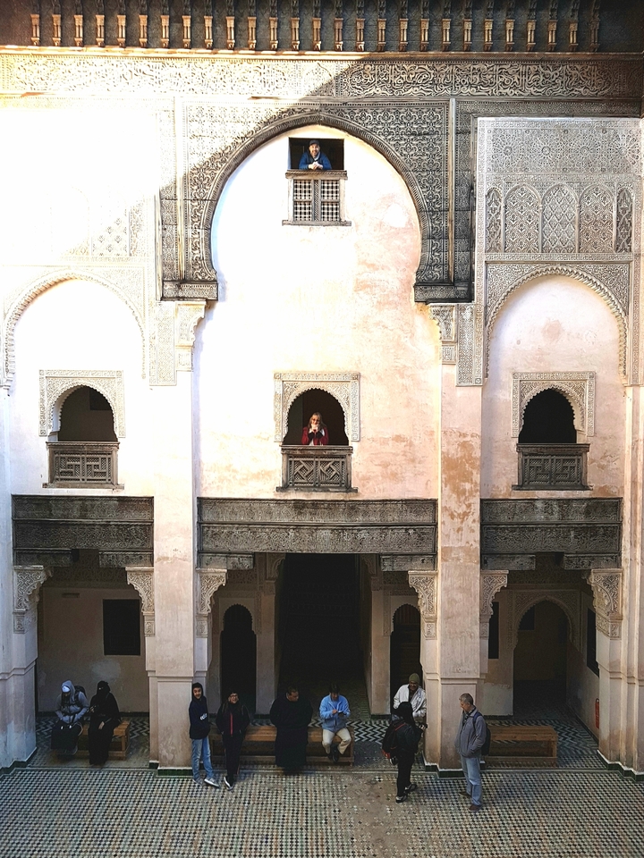 Femme debout sur le balcon d'un bâtiment historique.