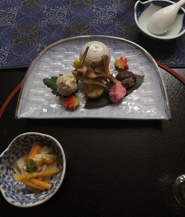 Présentation artistique de la cuisine japonaise traditionnelle sur une assiette en céramique.