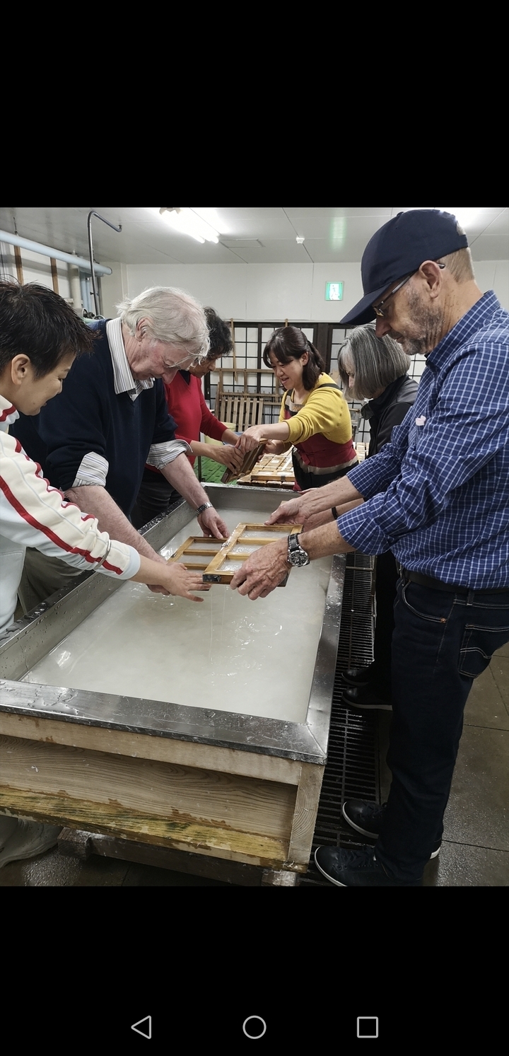 Des personnes participant activement à un processus traditionnel de fabrication de papier.