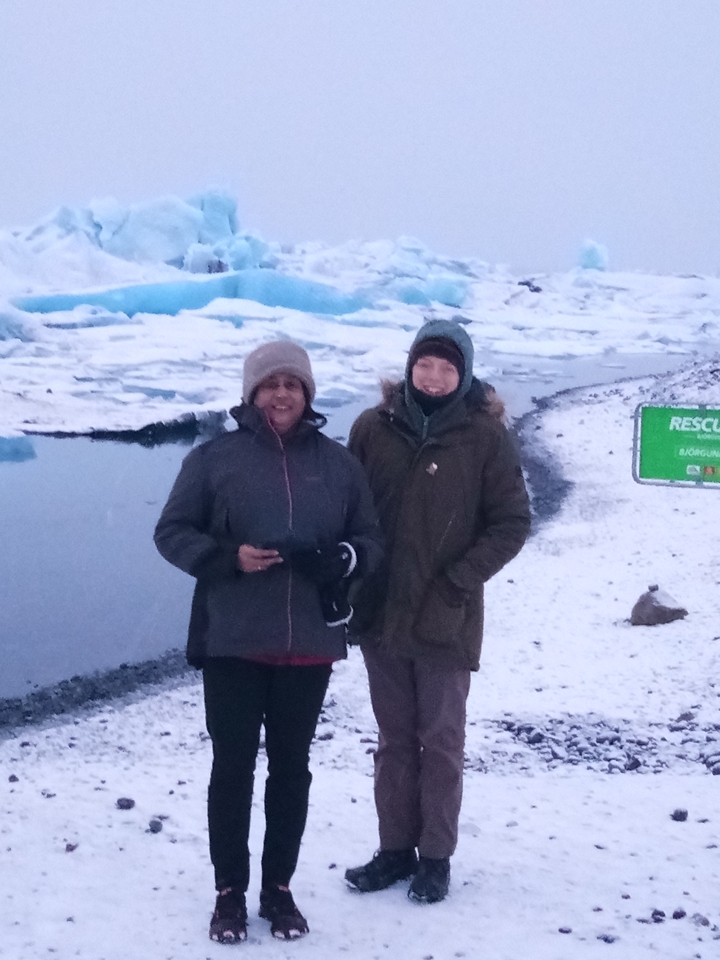 Deux personnes debout sur un paysage enneigé.