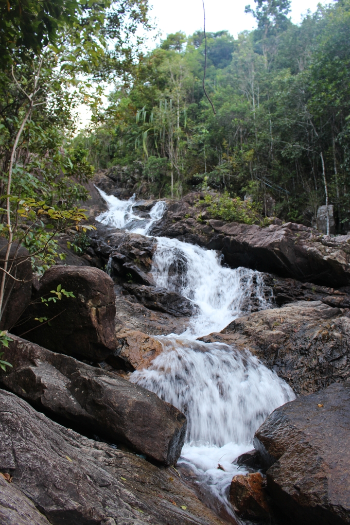 Waterfall flowing over rocks in nature.