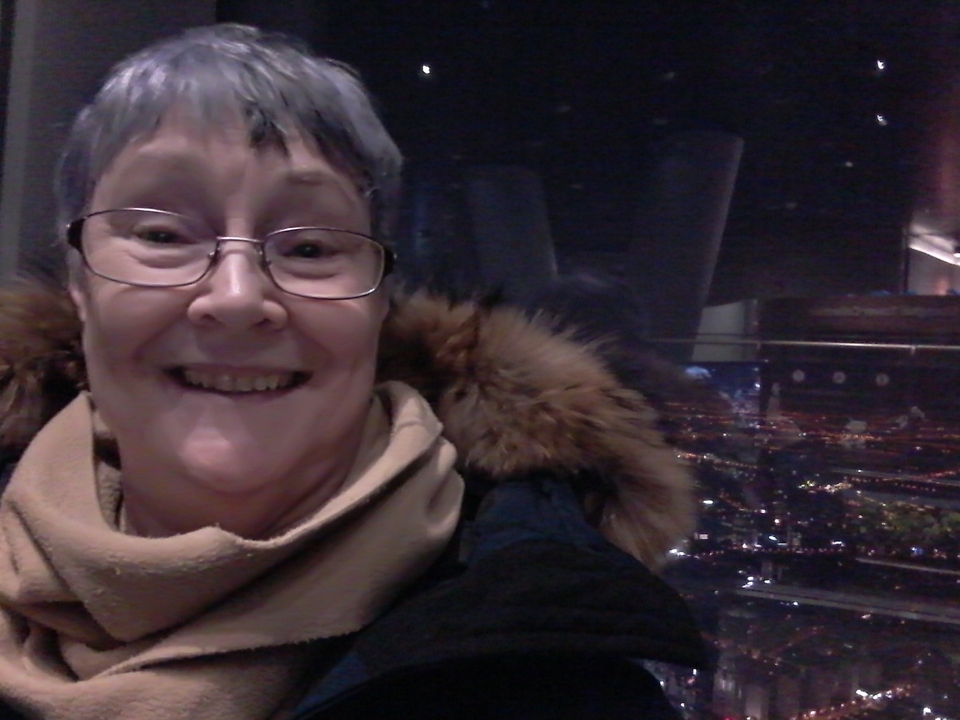 Selfie avec une vue nocturne de la ville en arrière-plan.