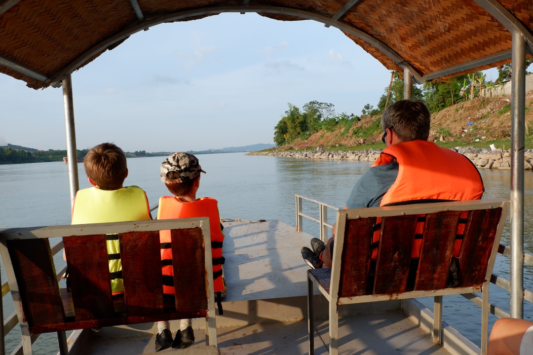 Famille en promenade en bateau sur une rivière calme.