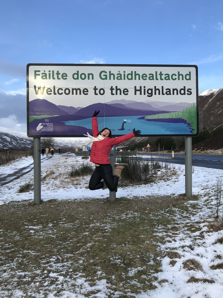 Large group photo on the beach with a banner.