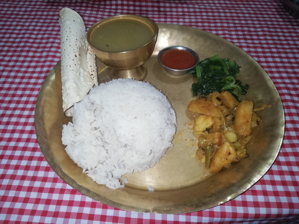 Repas népalais traditionnel servi dans une assiette en métal.