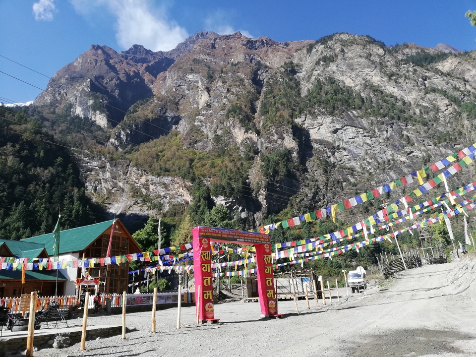 Entrée d'un monastère népalais avec des drapeaux de prière colorés.