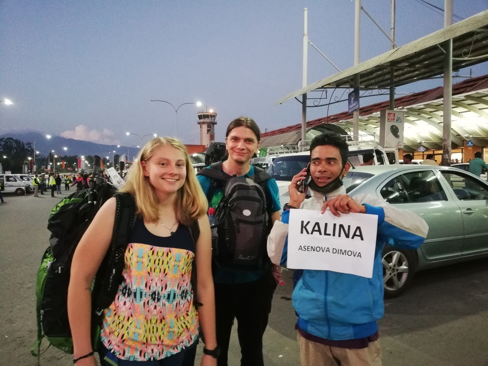 Groupe de voyageurs rencontrant un guide local à un aéroport.