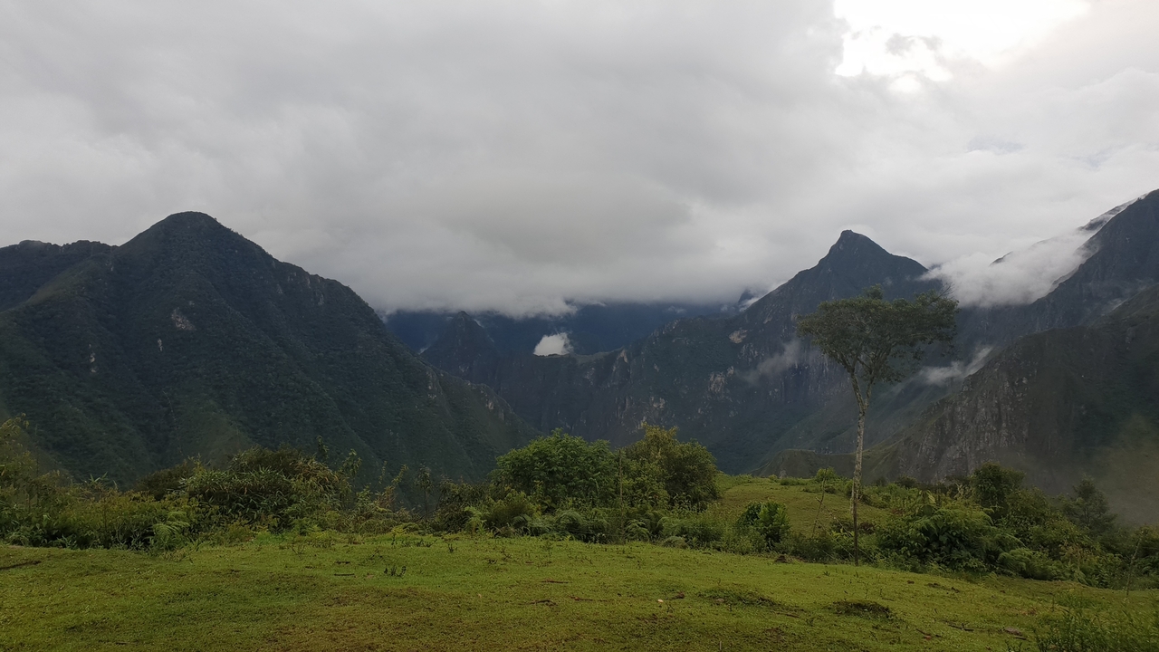 Paysage montagneux avec nuages et verdure.