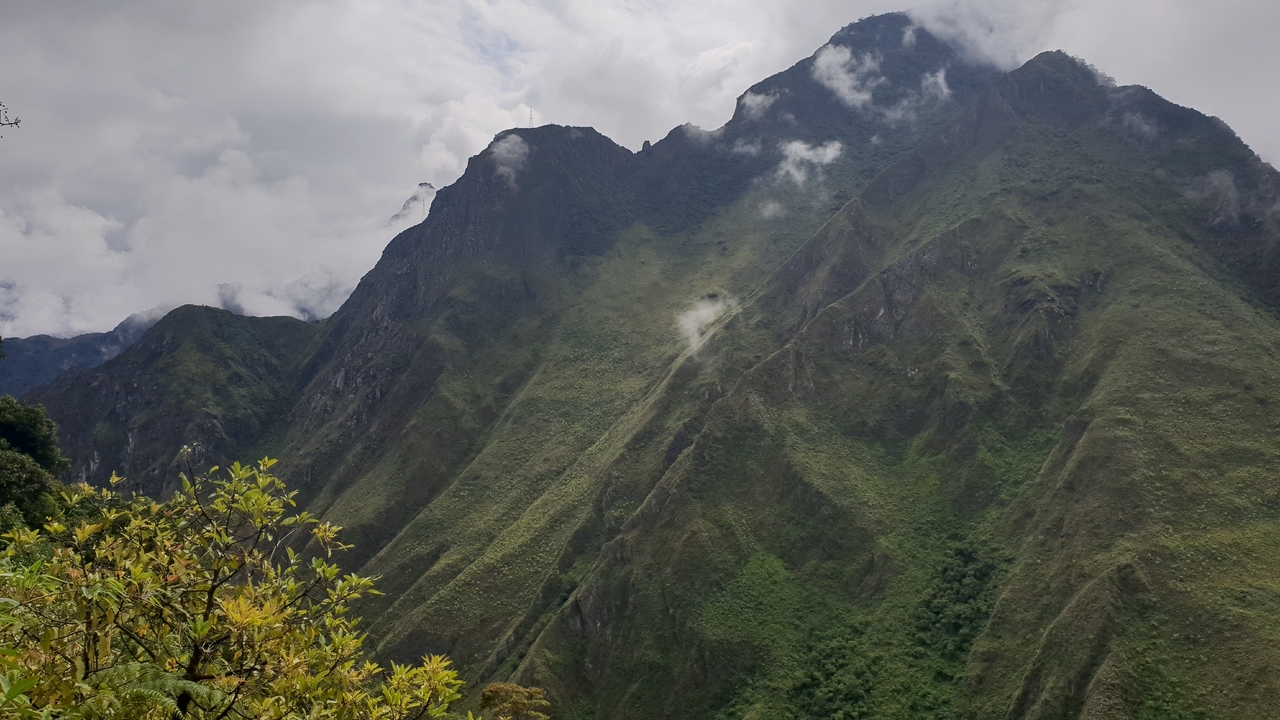 Pentes montagneuses escarpées avec de la verdure.