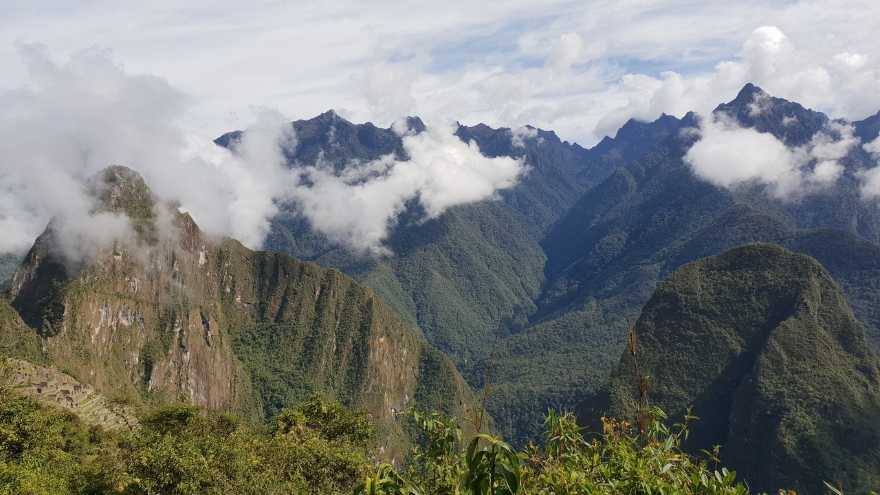 Sommets de montagne avec nuages et ciel bleu.