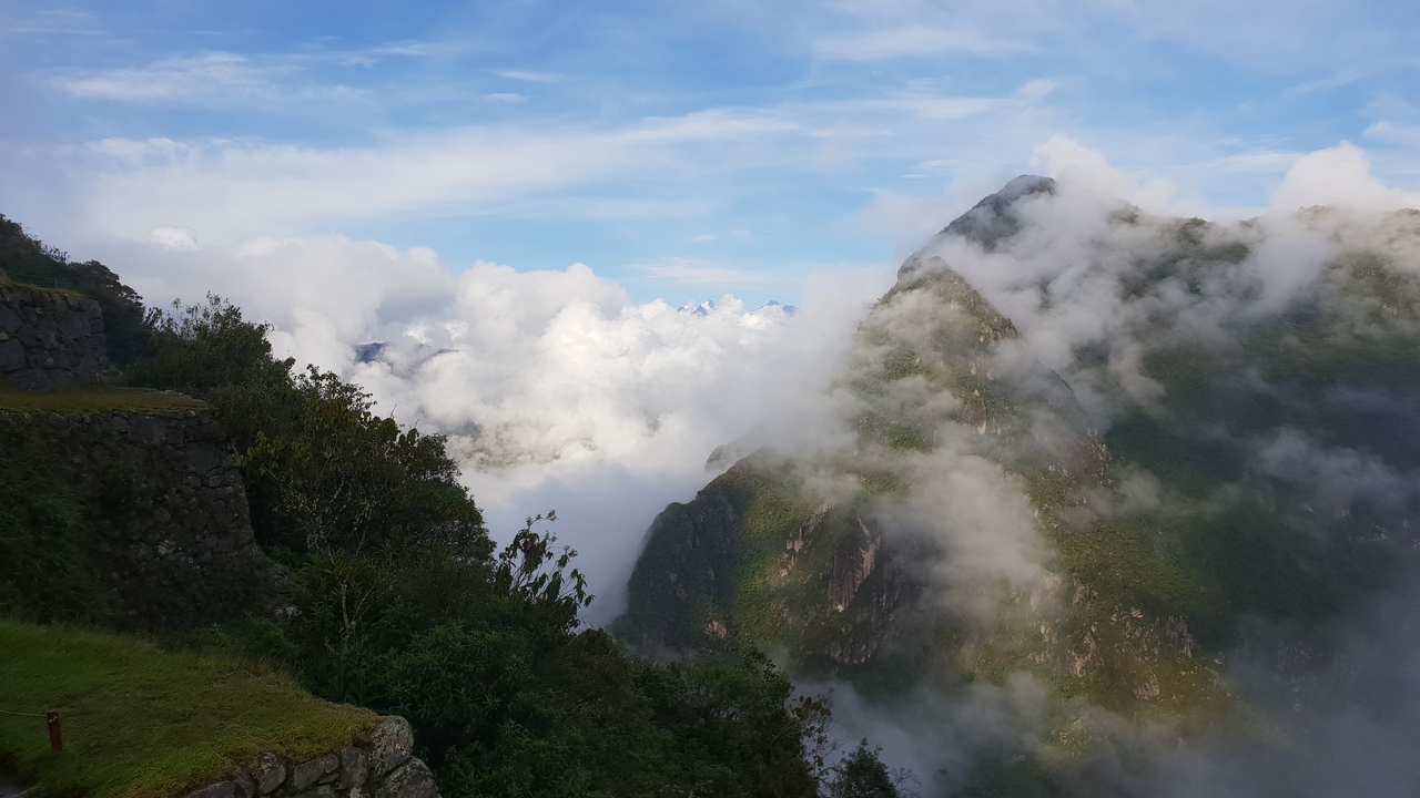Nuages et montagnes avec un ciel dramatique et la lumière du soleil qui perce à travers.