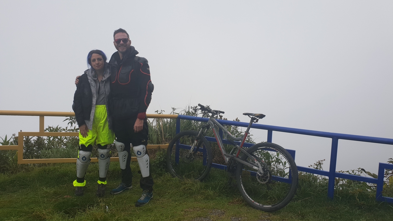 Un couple posant avec des vélos par une journée brumeuse.