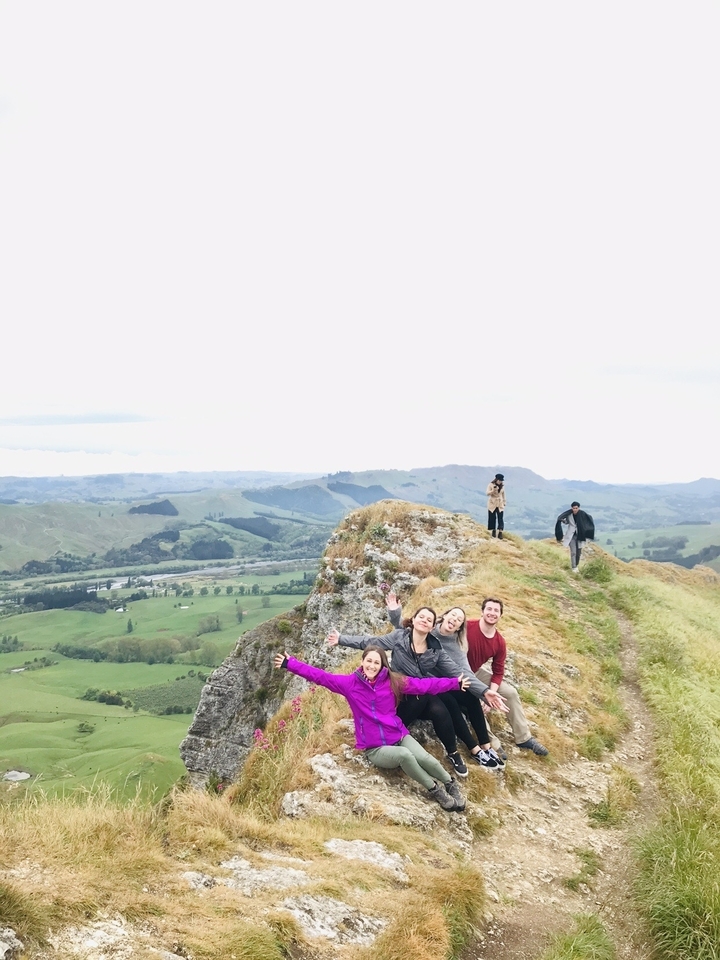 Des gens sur une colline avec une vue panoramique sur la campagne.
