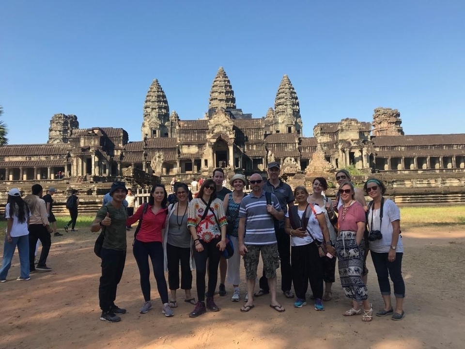 Group of people posing in front of the Angkor Wat temple.