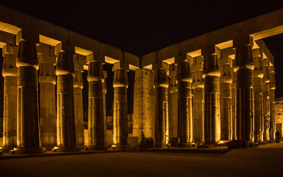 Temple de Louxor illuminé la nuit avec de grandes colonnes.