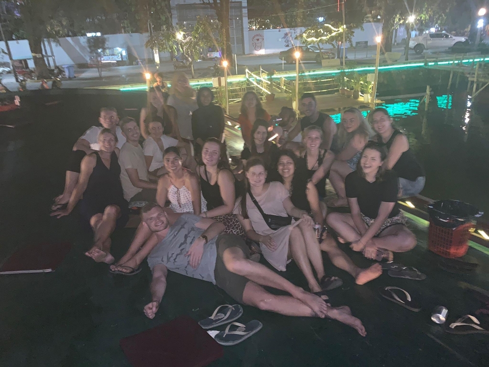 Grand groupe de personnes assises ensemble lors d'un événement nocturne.