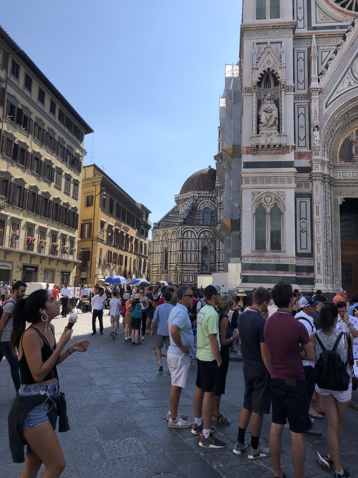 Place bondée avec des bâtiments historiques et beaucoup de monde.
