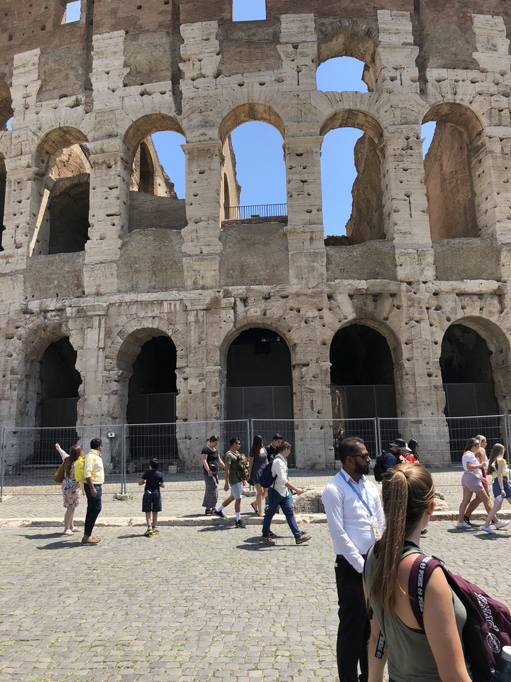 Des gens marchant devant le Colisée à Rome.