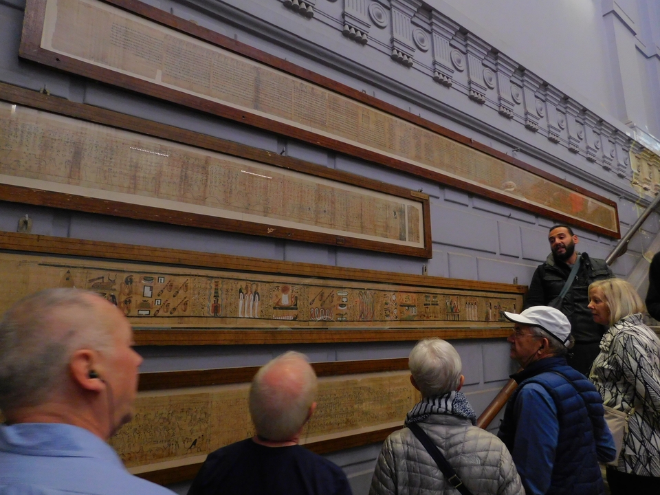 Un groupe de personnes observant d'anciens papyrus égyptiens dans un musée.