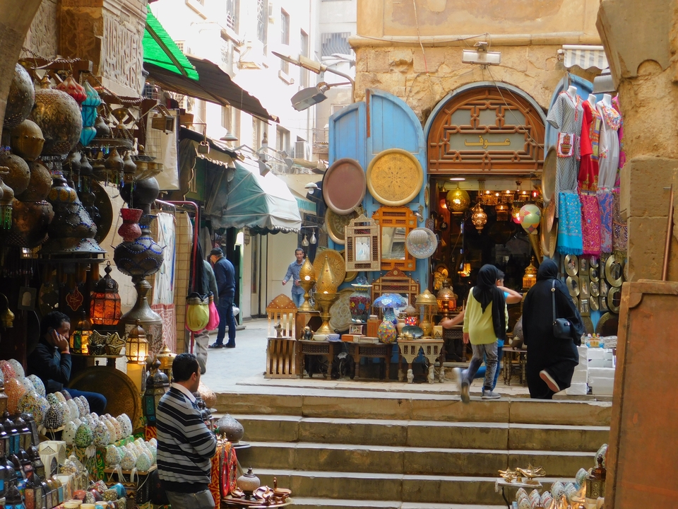 Une rue de marché animée en Égypte avec divers objets d'artisanat exposés.