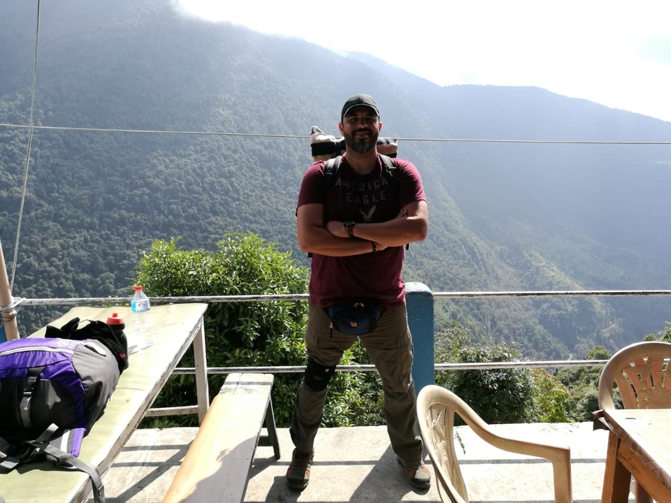 Homme posant devant une vue panoramique sur les montagnes.