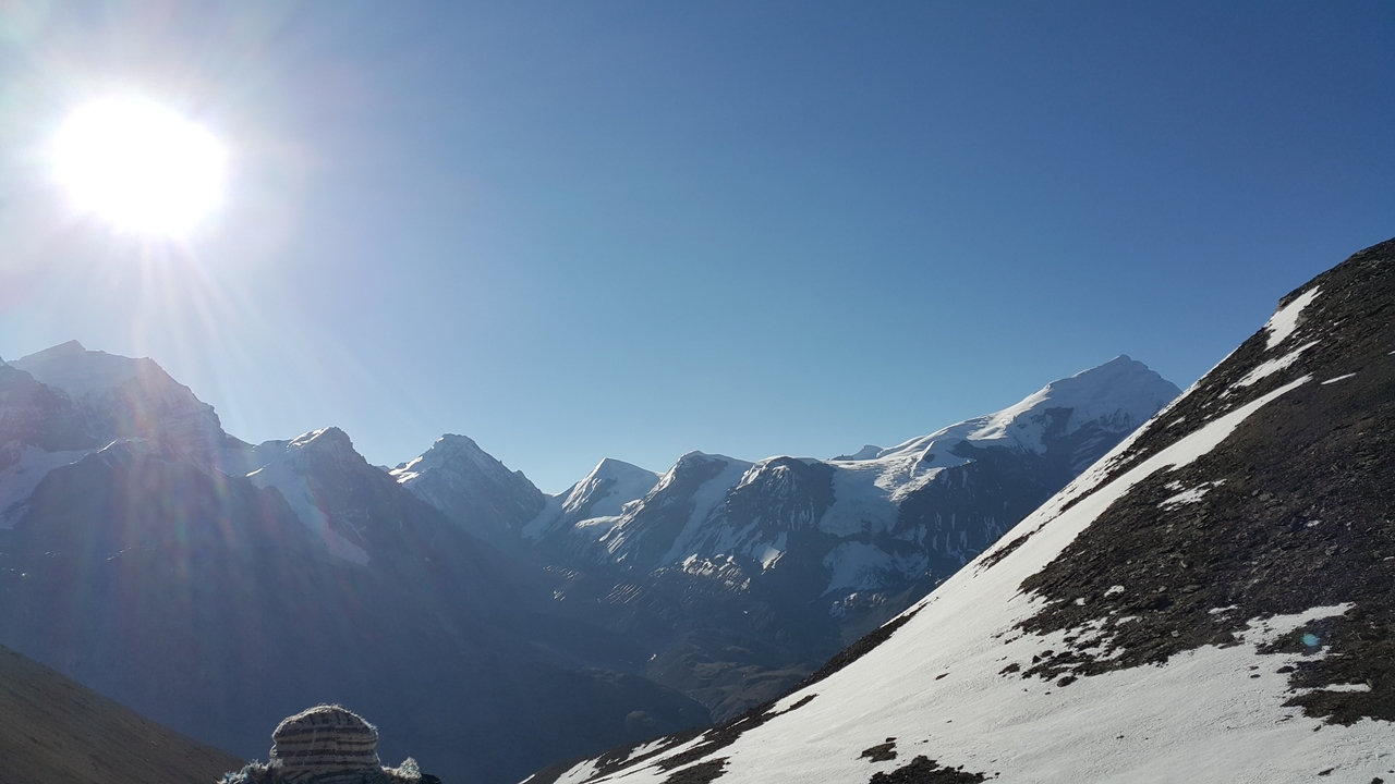 Le soleil brille sur les sommets enneigés des montagnes.