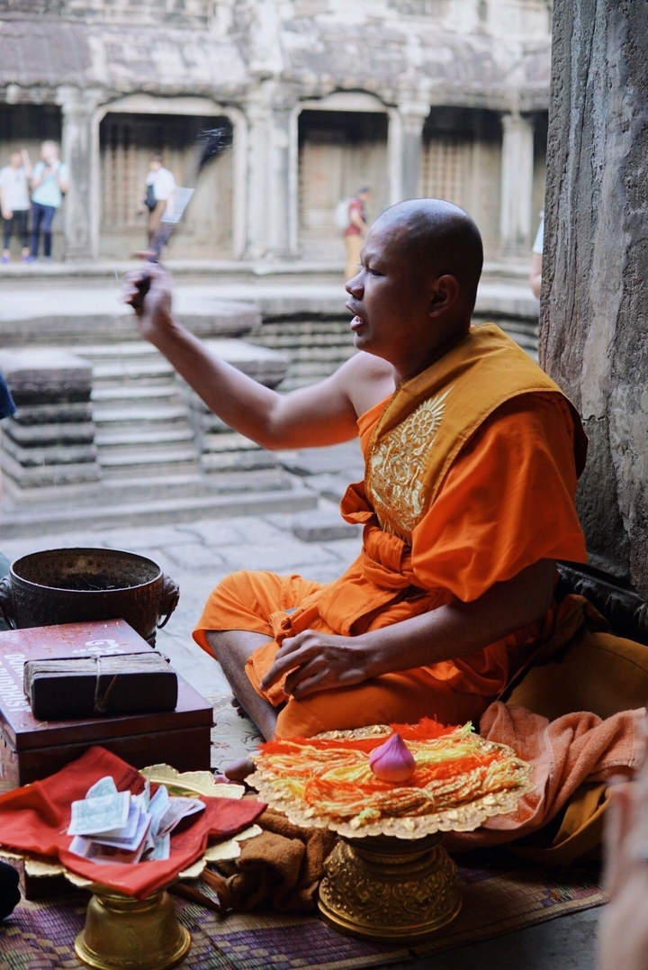 Moine en robe orange à l'intérieur d'un temple.