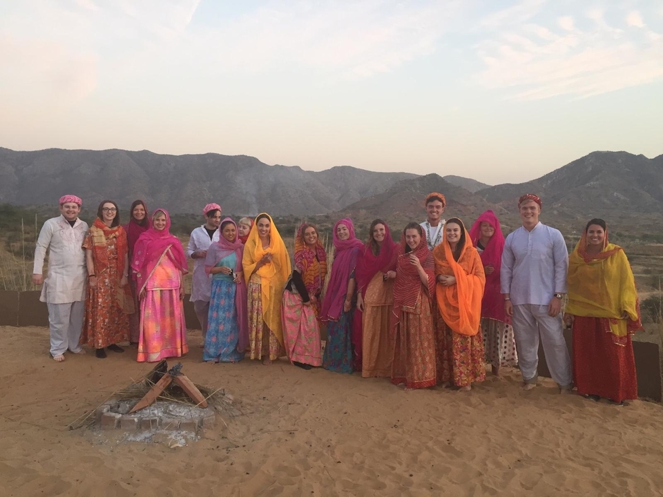 Groupe vêtu de tenues traditionnelles colorées avec des montagnes en arrière-plan.