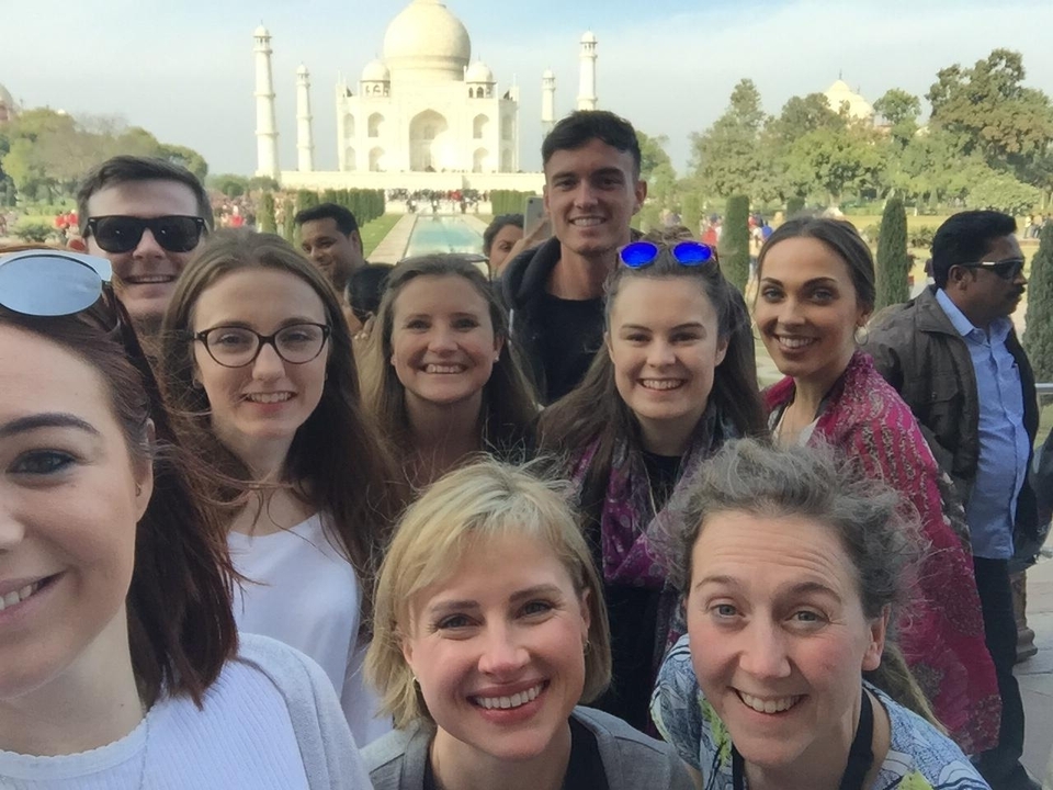 Selfie de groupe avec le Taj Mahal en arrière-plan.