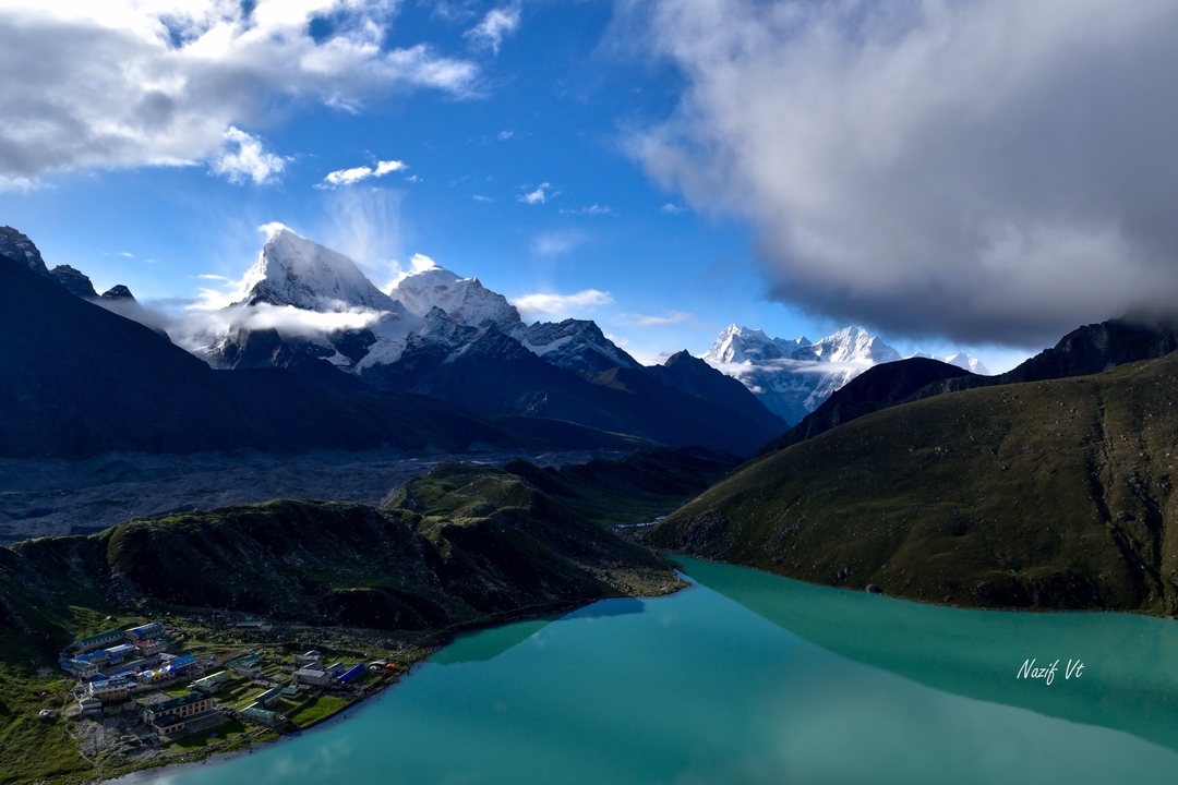 Lac limpide dans une vallée de montagne avec des sommets enneigés.