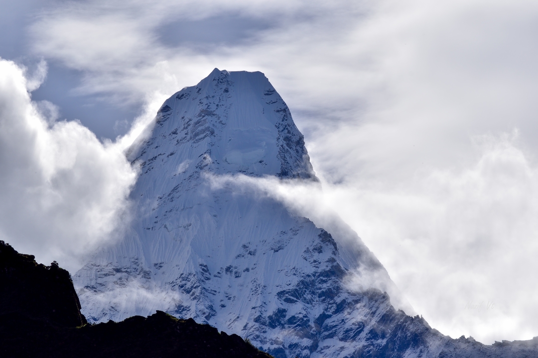 Montagne entourée de nuages.